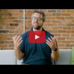 Still of video with red play button