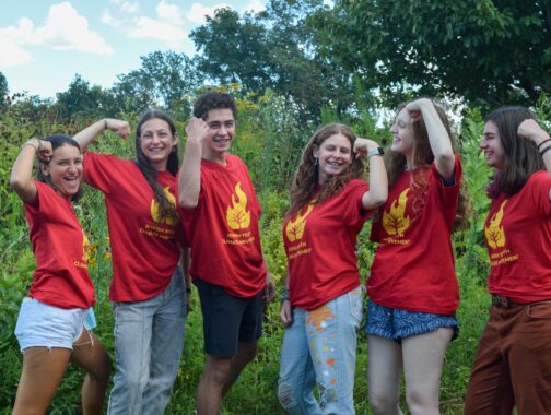 JYCM teens in red shirts flexing arms