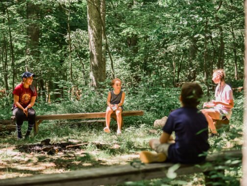 Kids sitting around a campfire in the woods