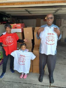 three people holding shirts saying "prayers on plates"