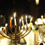 Multiple lit menorahs in a dark room
