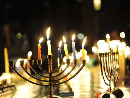 Multiple lit menorahs in a dark room